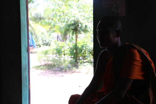 A monk from a nearby Khmer temple, who was waiting in the home of a farmer Eve interviewed. The man gave him a bag of rice for the monastery. (Photo: Eve Troeh)