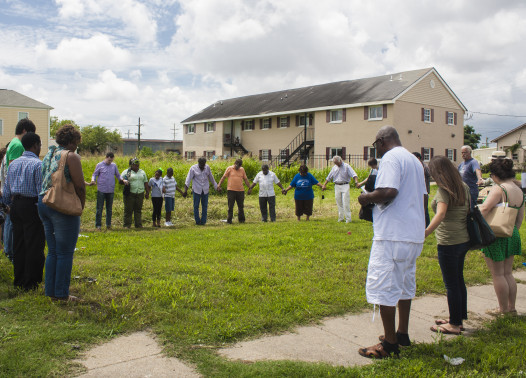 Community members join hands for a short service near the Zion City Greater St. James Church after guest speeches. (Photo: Hanna Rasanen)