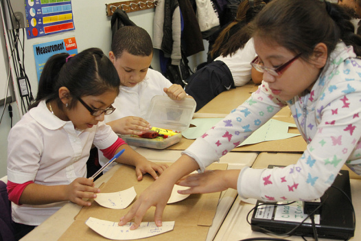 Embedded artists and traditional teachers co-teach classes.